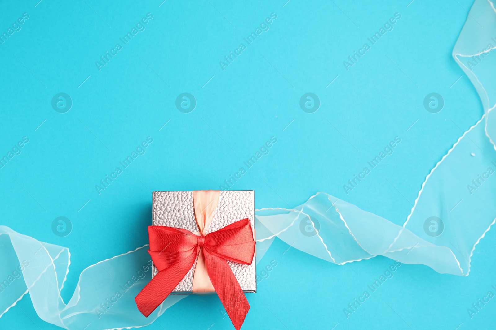 Photo of Romantic gift on light blue background, top view. Space for text