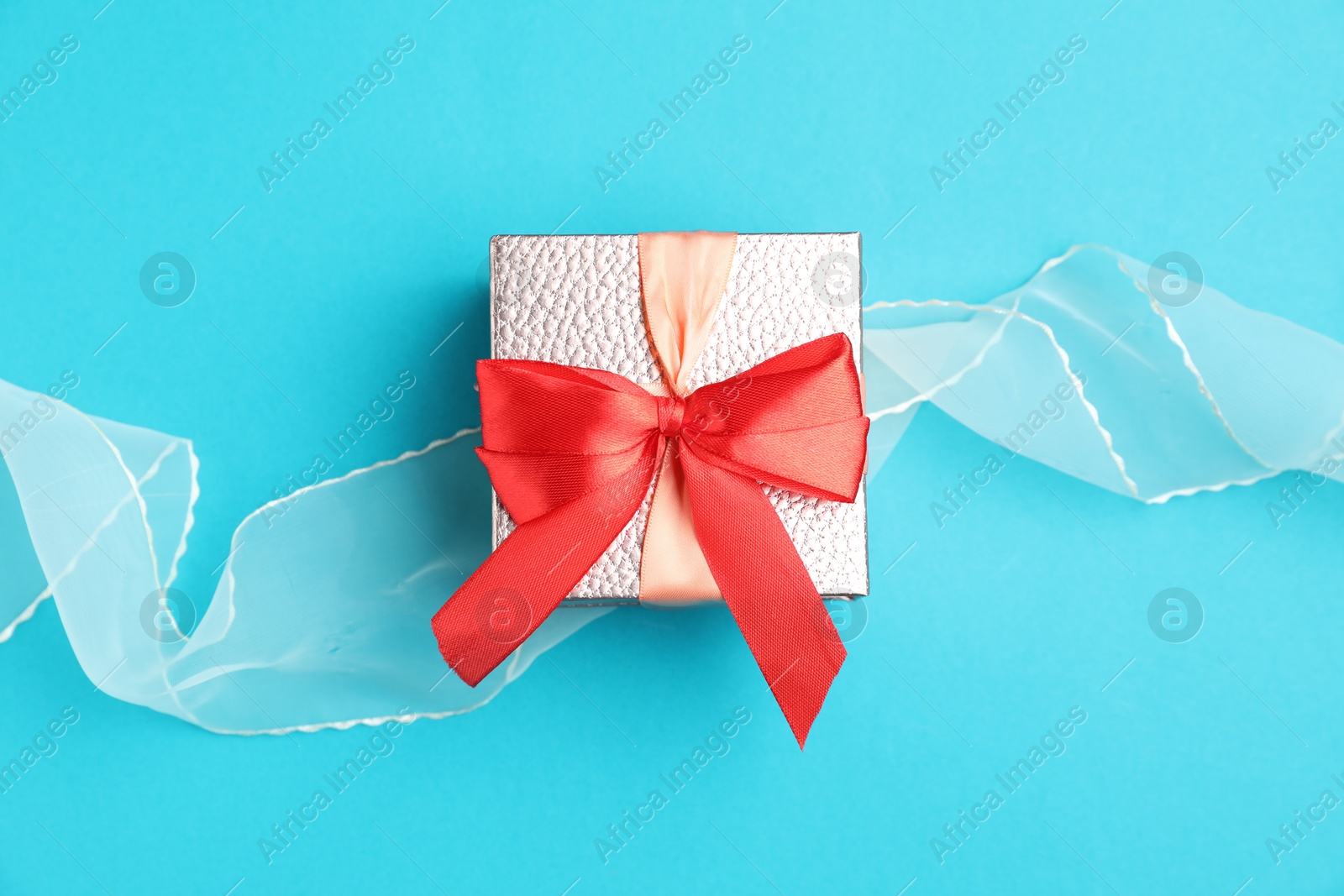 Photo of Romantic gift on light blue background, top view