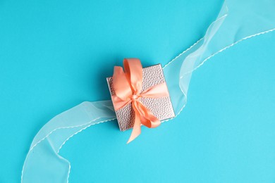 Photo of Romantic gift on light blue background, top view