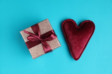 Romantic gift and heart on light blue background, top view