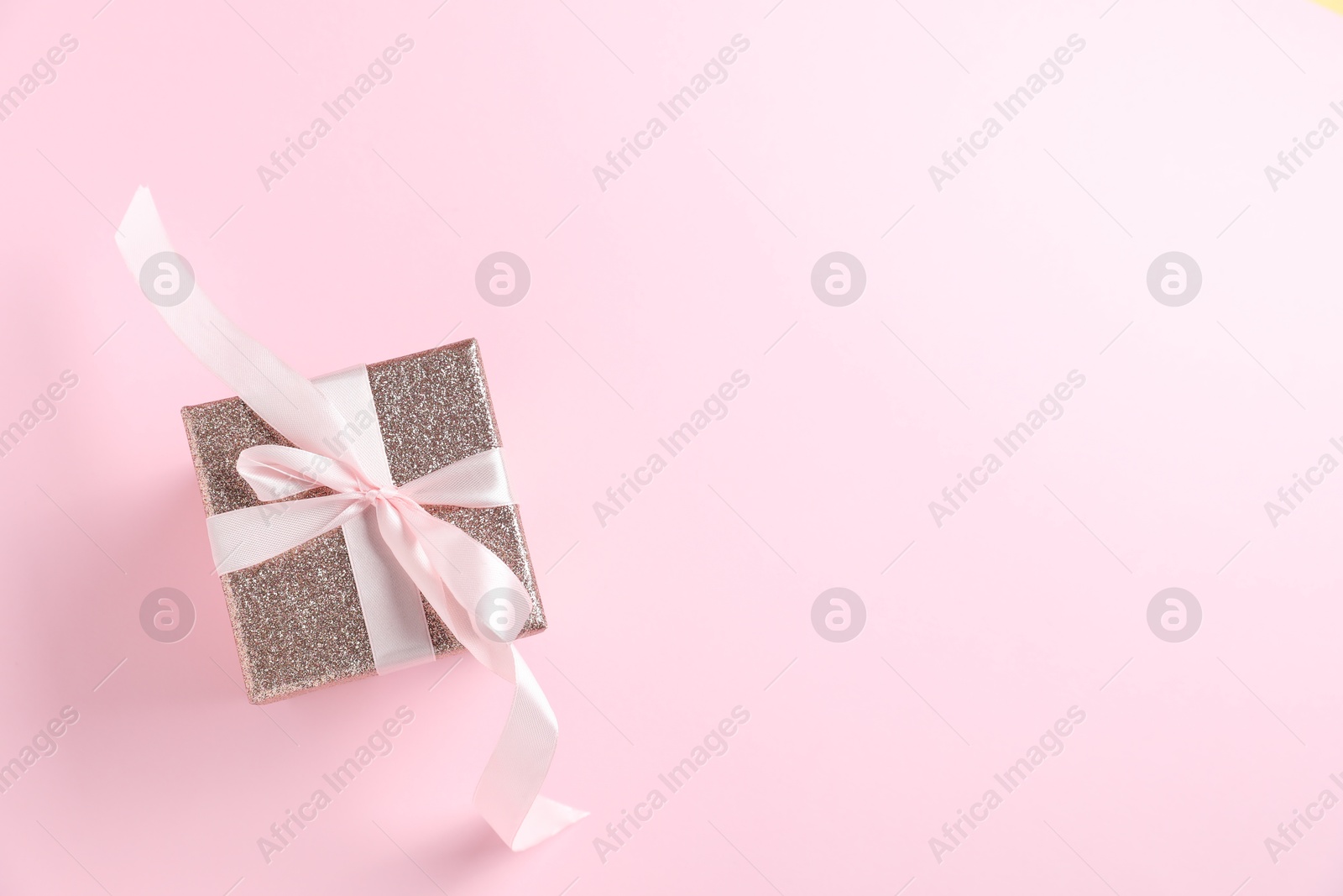 Photo of Romantic gift on light pink background, top view. Space for text