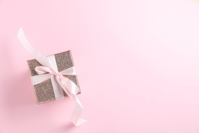 Romantic gift on light pink background, top view. Space for text