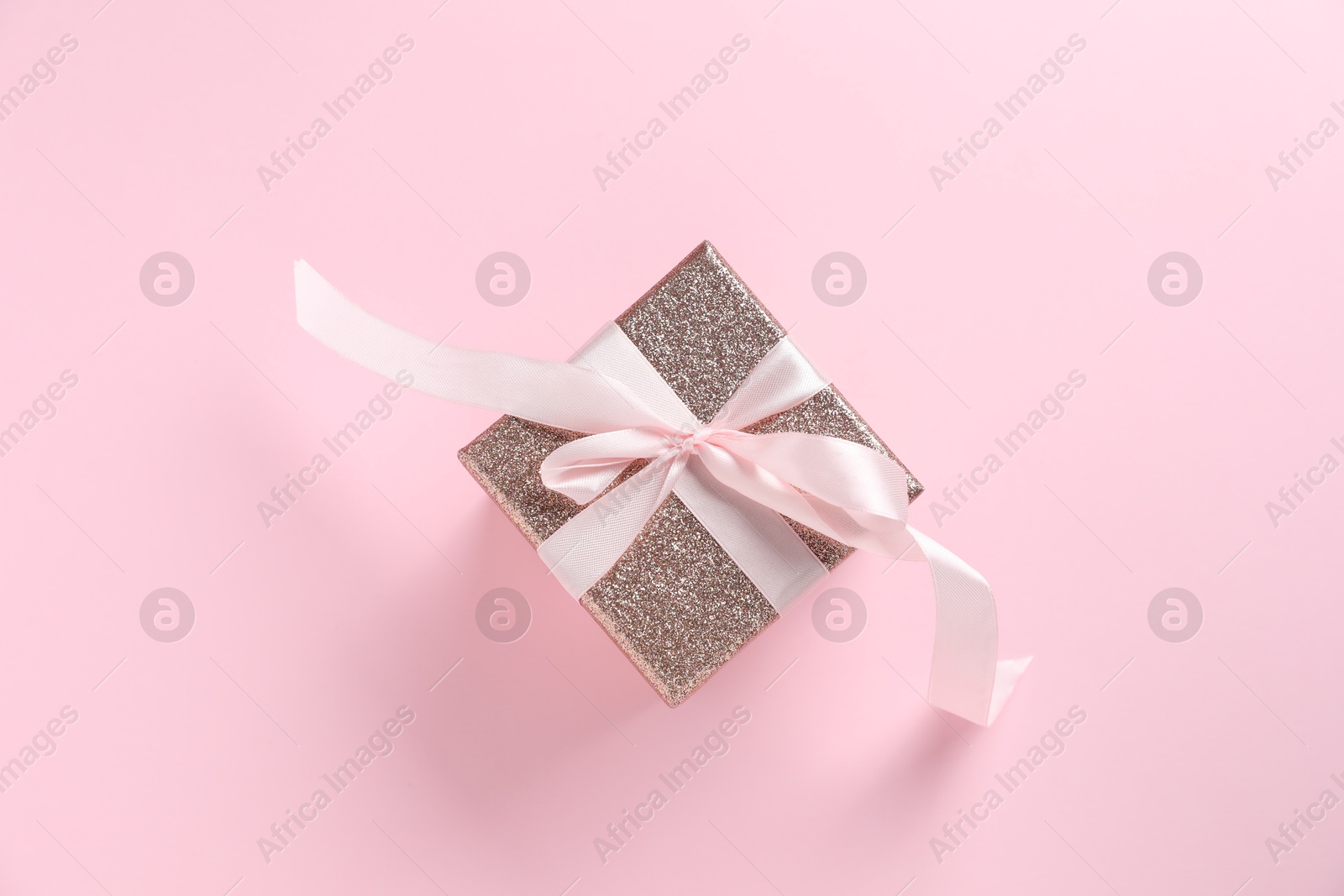 Photo of Romantic gift on light pink background, top view