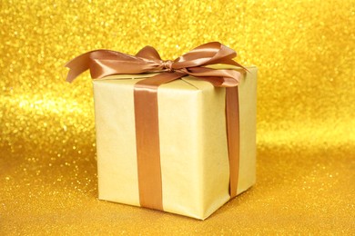 Photo of Romantic gift on golden glitter background, closeup