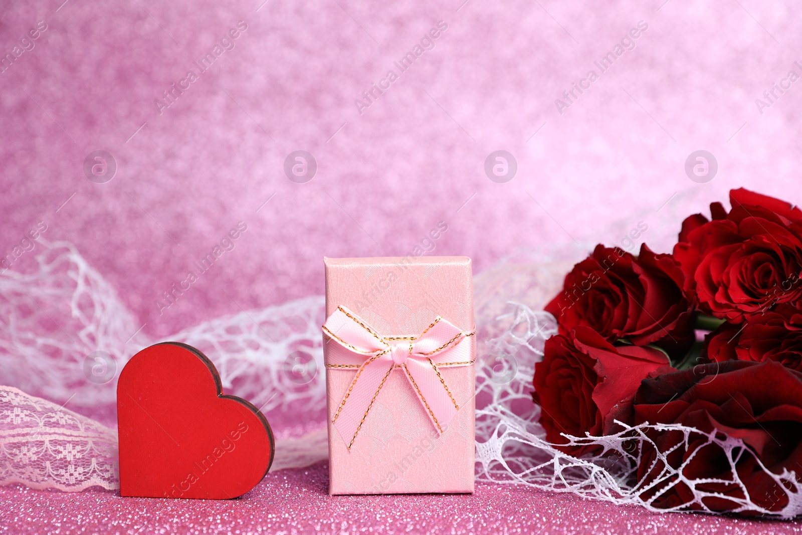 Photo of Romantic gift, heart and roses on pink background