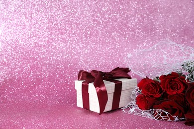 Photo of Romantic gift and roses on pink background. Space for text