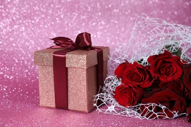 Romantic gift and roses on pink background, closeup