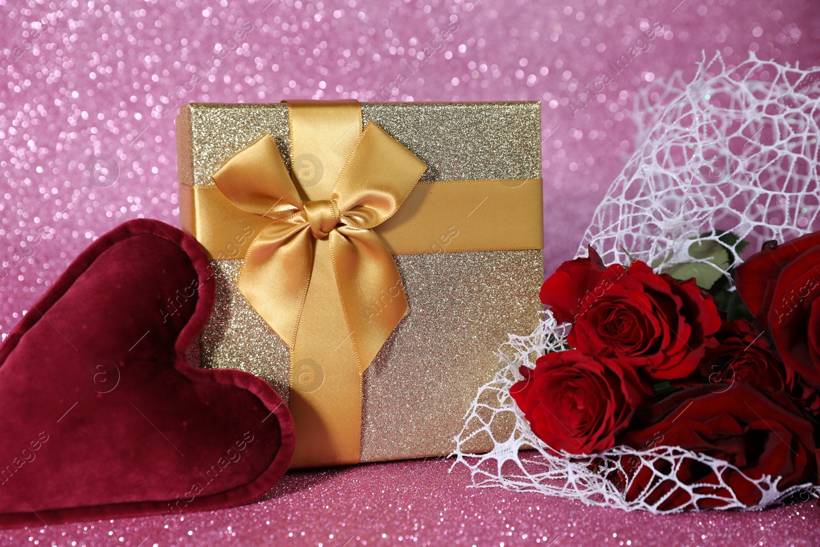 Photo of Romantic gift, heart and roses on pink background, closeup