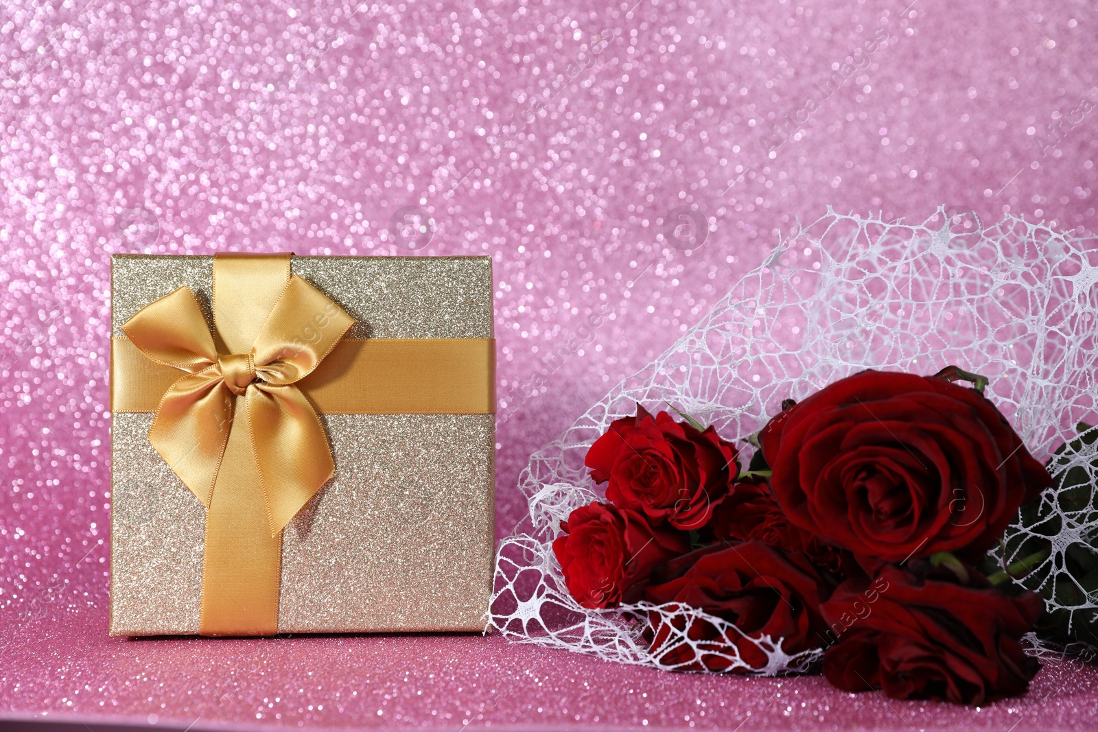 Photo of Romantic gift and roses on pink background