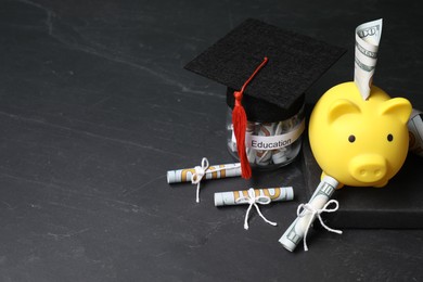 Photo of Tuition payment. Piggy bank, graduate hat, book, dollar banknotes and glass jar with word Education on black table. Space for text