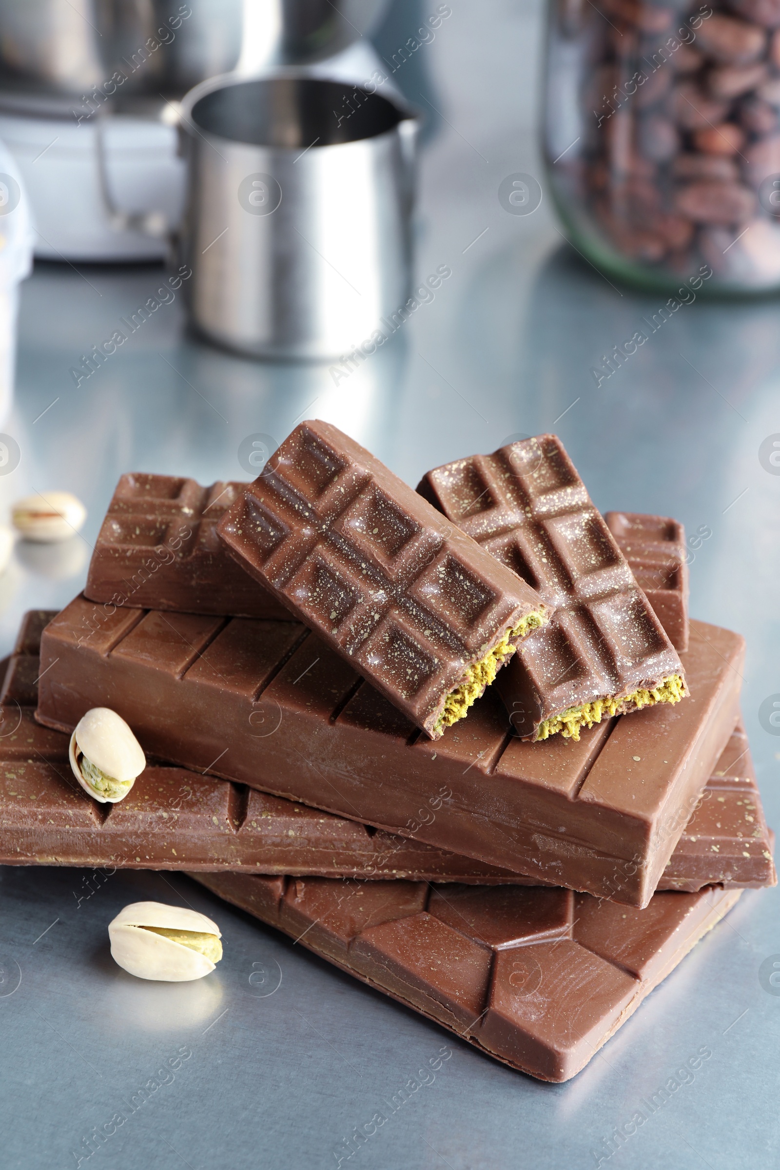 Photo of Stack of tasty Dubai chocolate bars with pistachios and knafeh on grey table