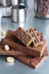 Photo of Stack of tasty Dubai chocolate bars with pistachios and knafeh on grey table