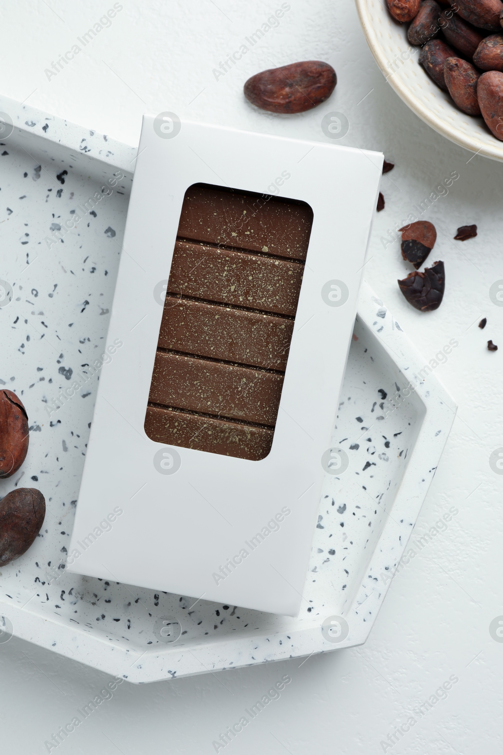 Tasty Dubai chocolate bar in package with pistachios, knafeh and cocoa beans on white table, flat lay. Space for text Photo of Tasty Dubai chocolate bar in package with pistachios, knafeh and cocoa beans on white table, flat lay. Space for text
