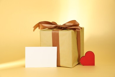 Photo of Romantic gift, heart and blank card on beige background. Space for text