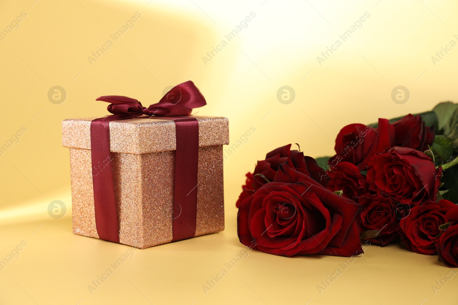 Photo of Romantic gift and roses on beige background