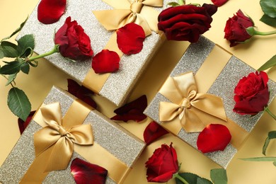 Photo of Romantic gifts and roses on beige background, flat lay