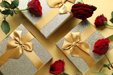 Photo of Romantic gifts and roses on beige background, flat lay