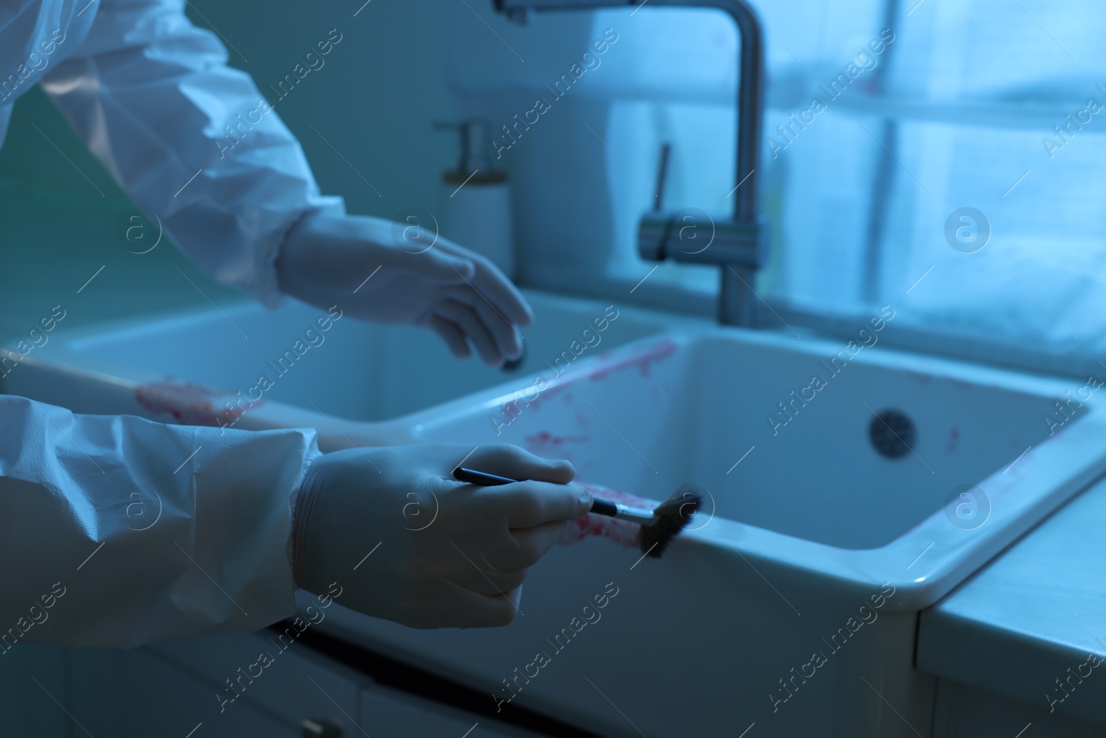 Photo of Forensic expert taking fingerprints from sink with brush at crime scene indoors, closeup