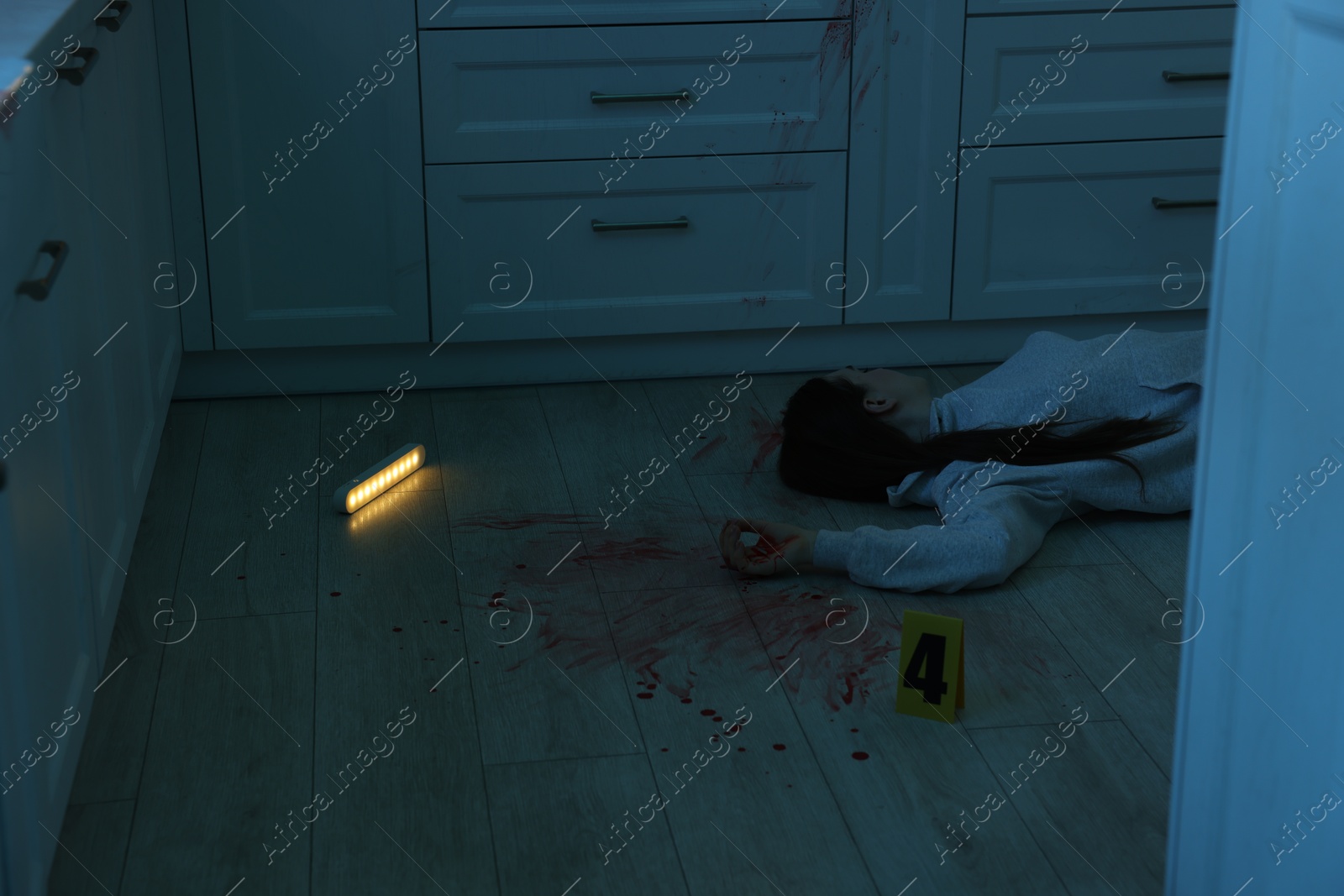 Photo of Dead woman's body on floor in dark room