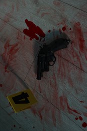 Photo of Gun and smeared blood on floor at crime scene