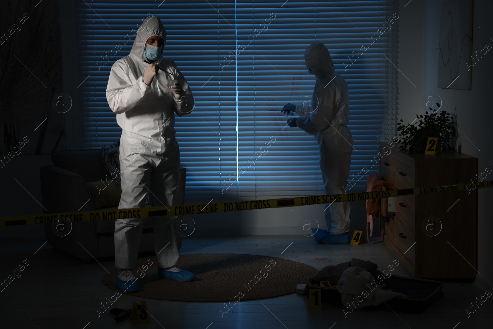 Photo of Forensic experts working at crime scene in dark room