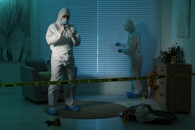 Forensic experts working at crime scene indoors