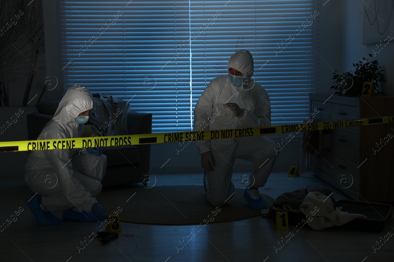 Photo of Forensic experts working at crime scene in dark room