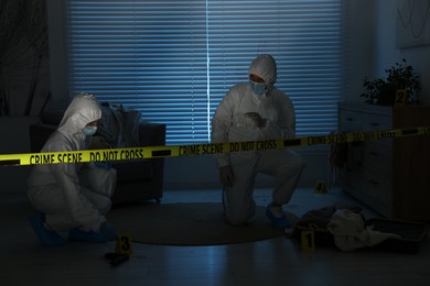 Photo of Forensic experts working at crime scene in dark room