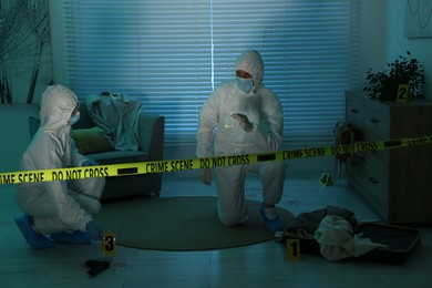 Photo of Forensic experts working at crime scene indoors