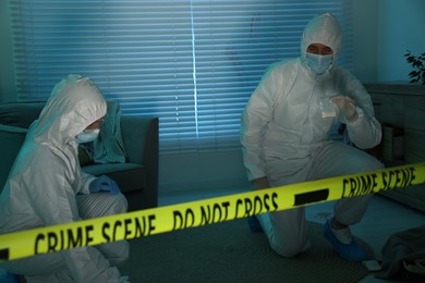 Photo of Forensic experts working at crime scene indoors