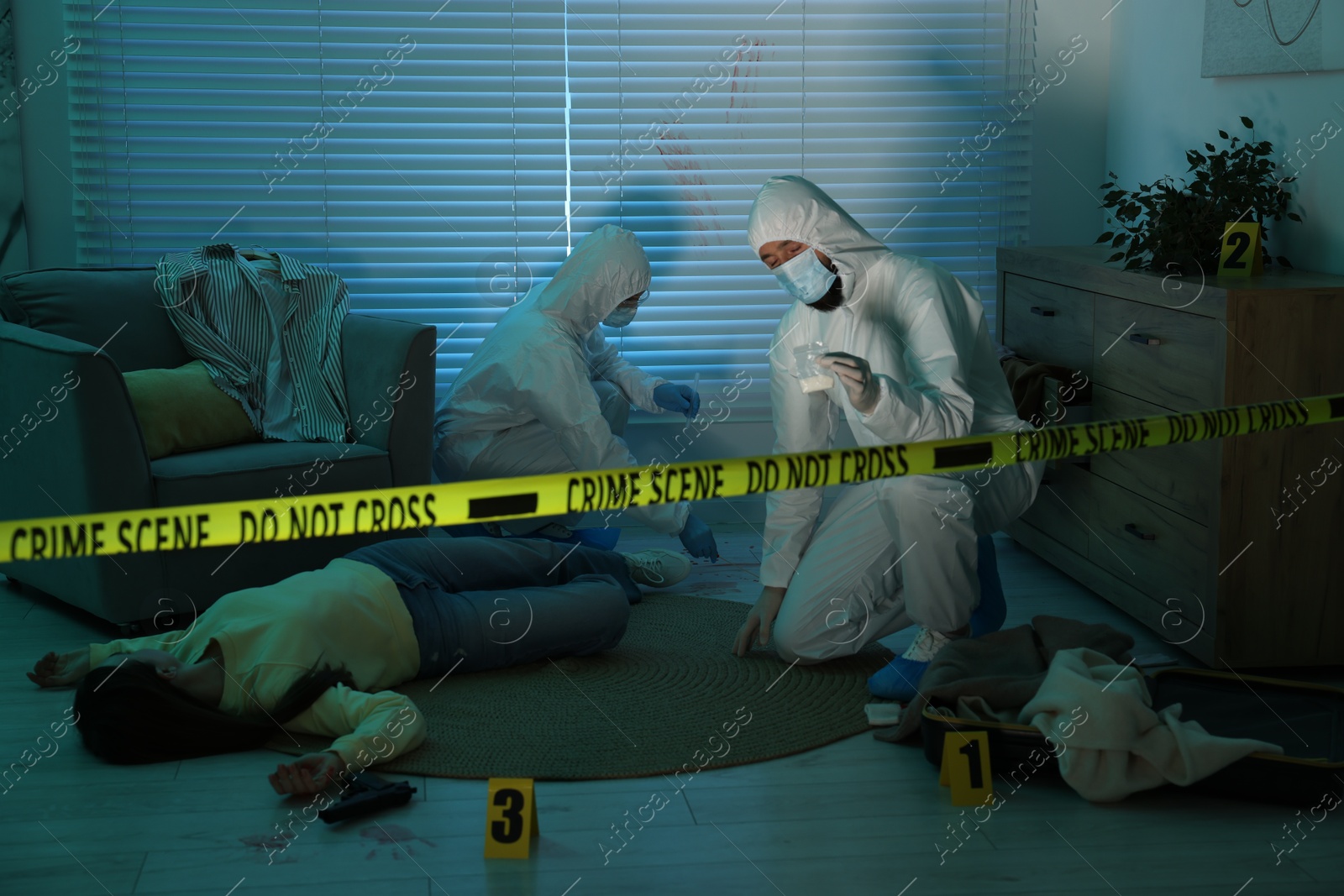 Photo of Forensic experts working at crime scene with dead woman's body indoors