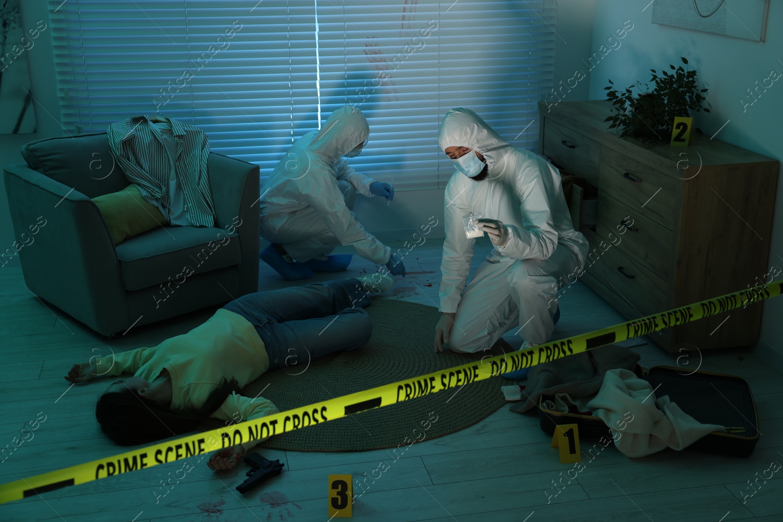 Photo of Forensic experts working at crime scene with dead woman's body indoors