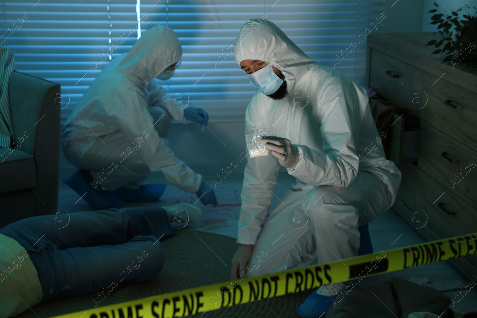 Photo of Forensic experts working at crime scene with dead woman's body indoors