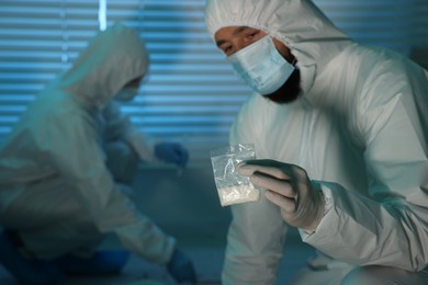 Photo of Forensic experts working at crime scene indoors, selective focus