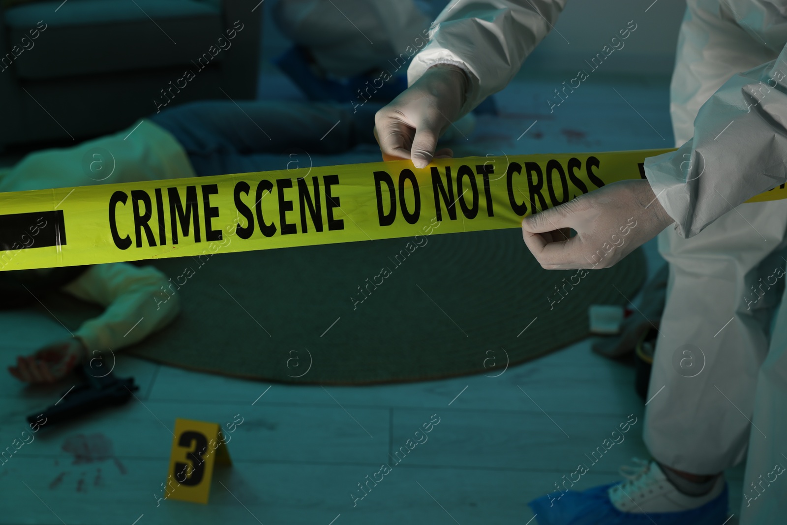 Photo of Forensic expert with yellow crime scene tape and dead woman's body indoors, closeup