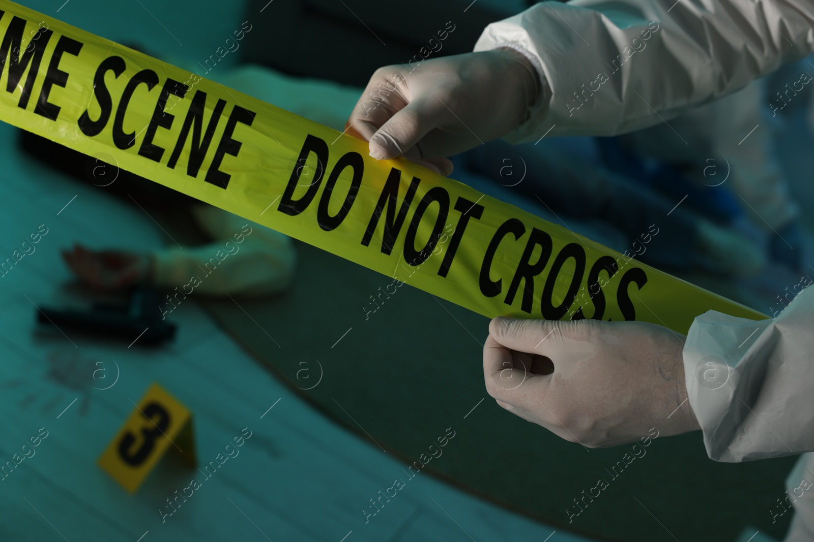 Photo of Forensic expert with yellow crime scene tape and dead woman's body indoors, closeup