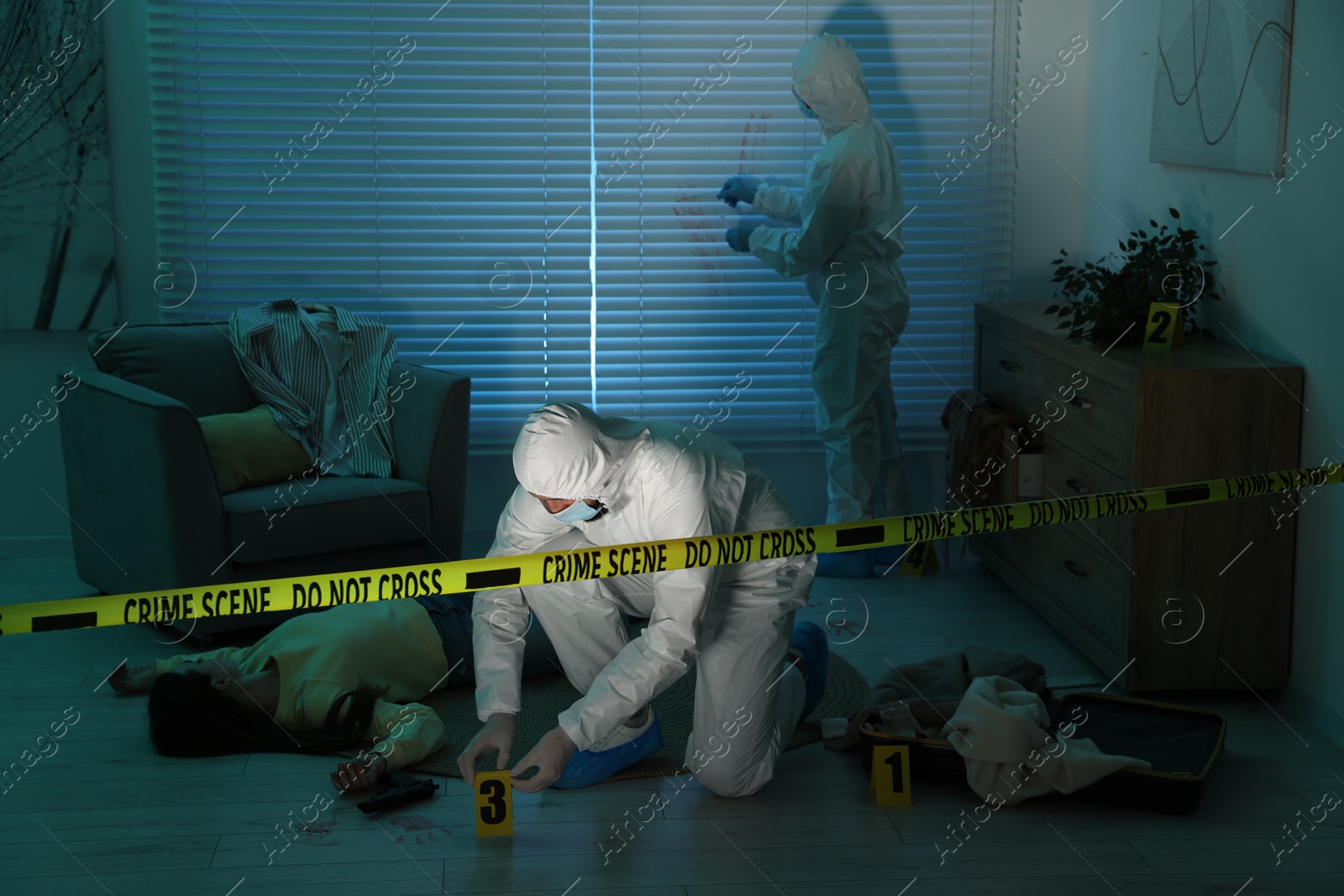 Photo of Forensic experts working at crime scene with dead woman's body indoors