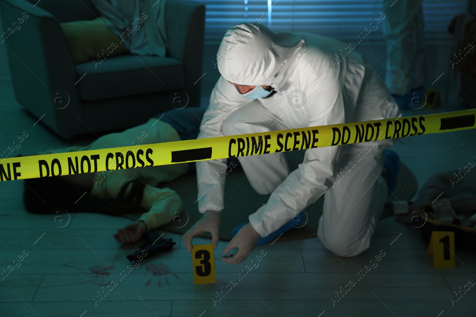 Photo of Forensic experts working at crime scene with dead woman's body indoors