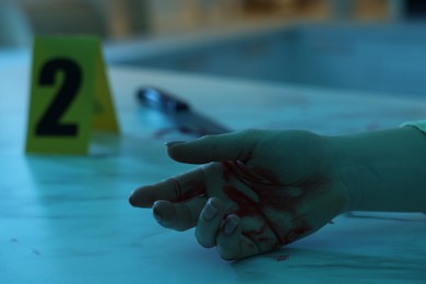 Photo of Dead woman's body with blood on marble countertop indoors, closeup