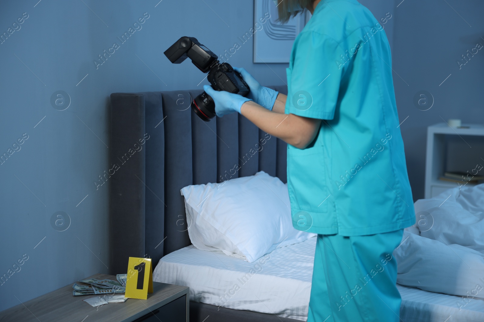 Photo of Forensic expert with camera working at crime scene indoors, closeup