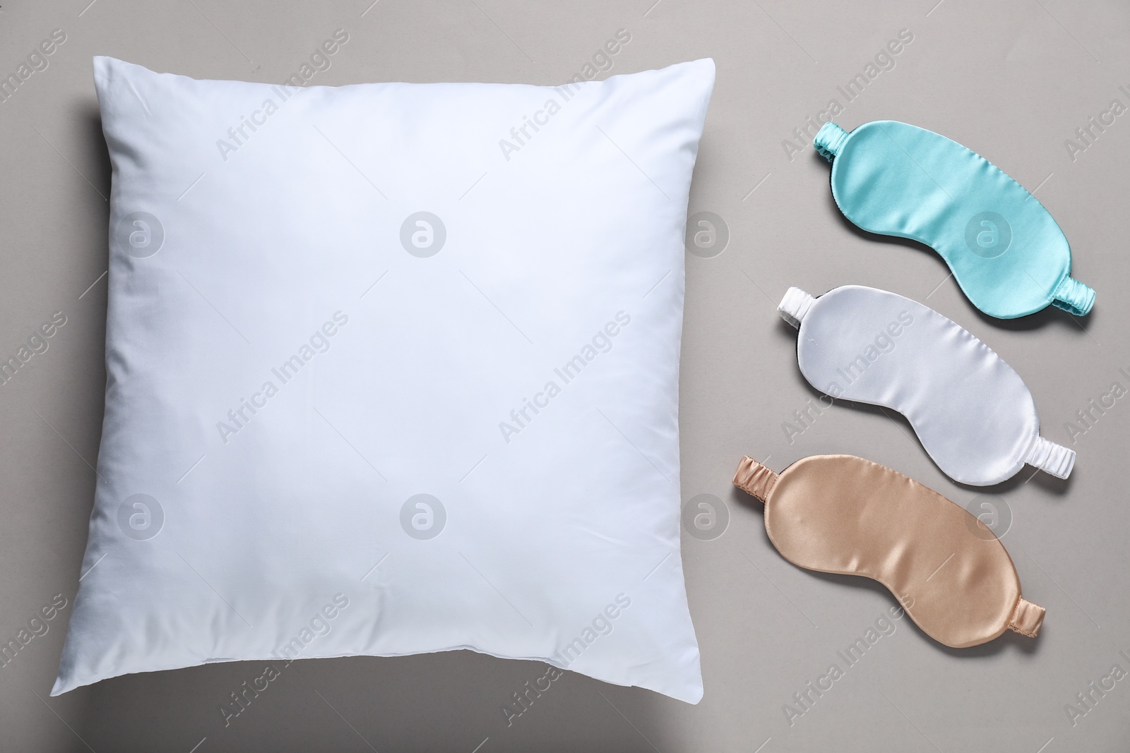 Photo of Blank sleep masks and pillow for branding on grey background, flat lay. Mockup for design