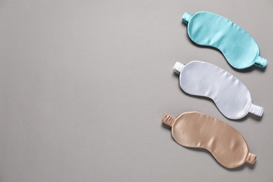 Photo of Different blank sleep masks for branding on grey background, flat lay. Mockup for design