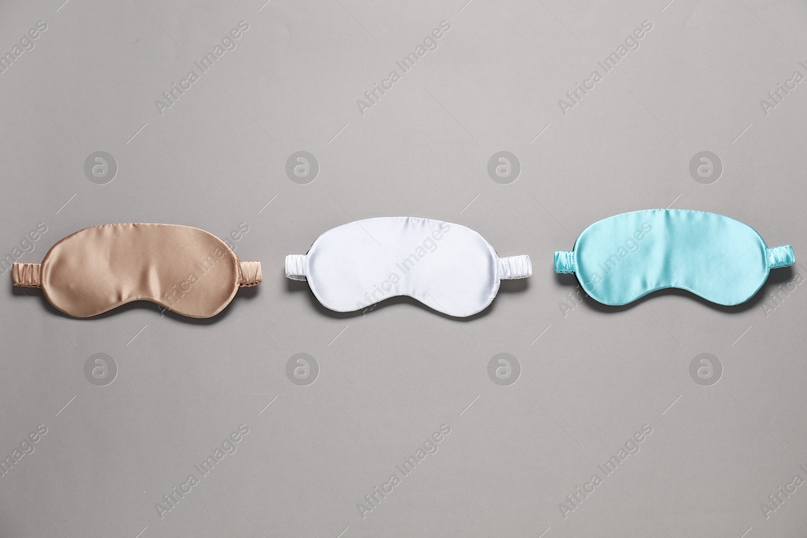 Photo of Different blank sleep masks for branding on grey background, flat lay. Mockup for design