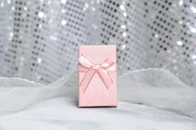 Romantic gift on table against silver glitter background