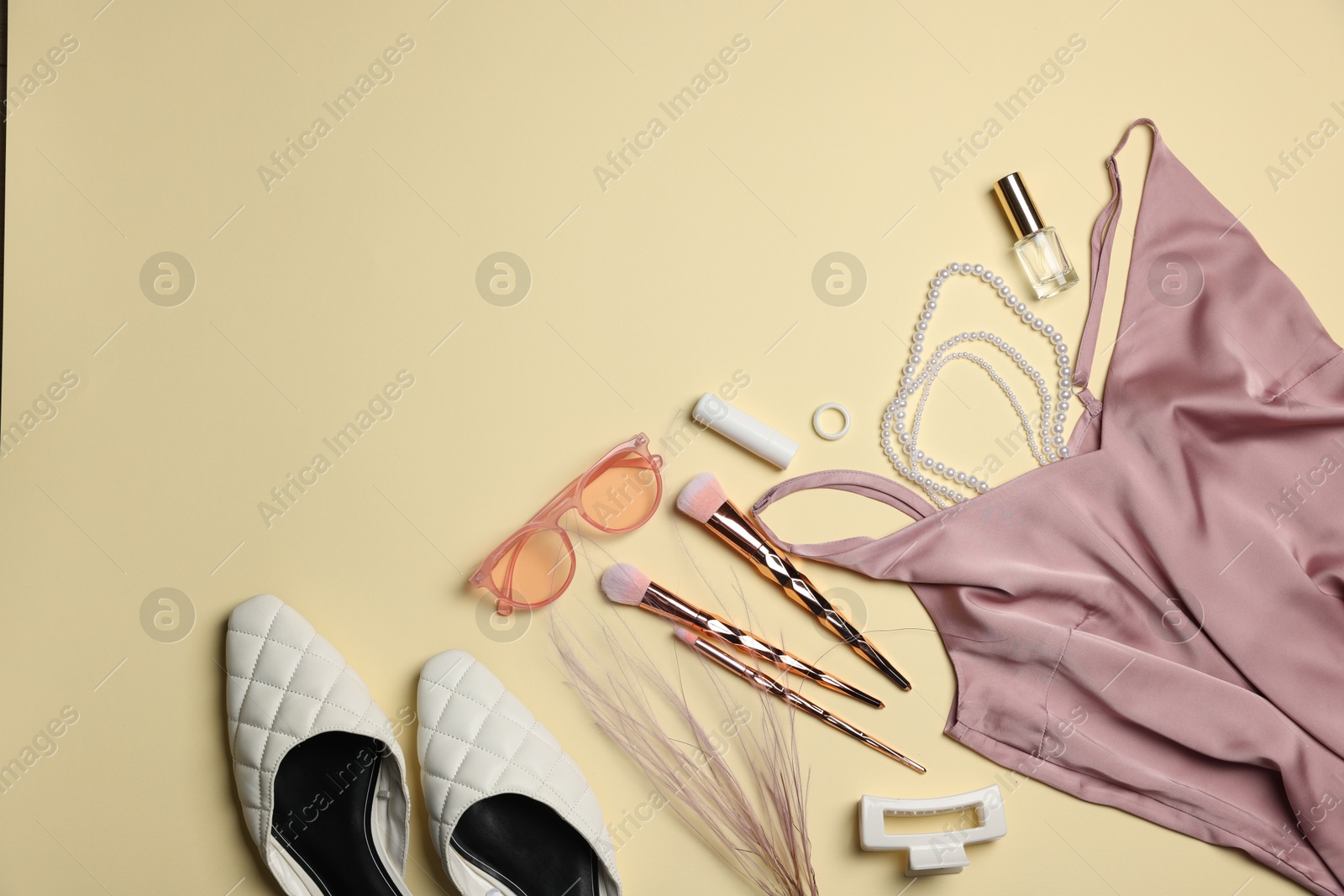 Photo of Stylish women's clothes and different accessories on beige background, flat lay. Space for text