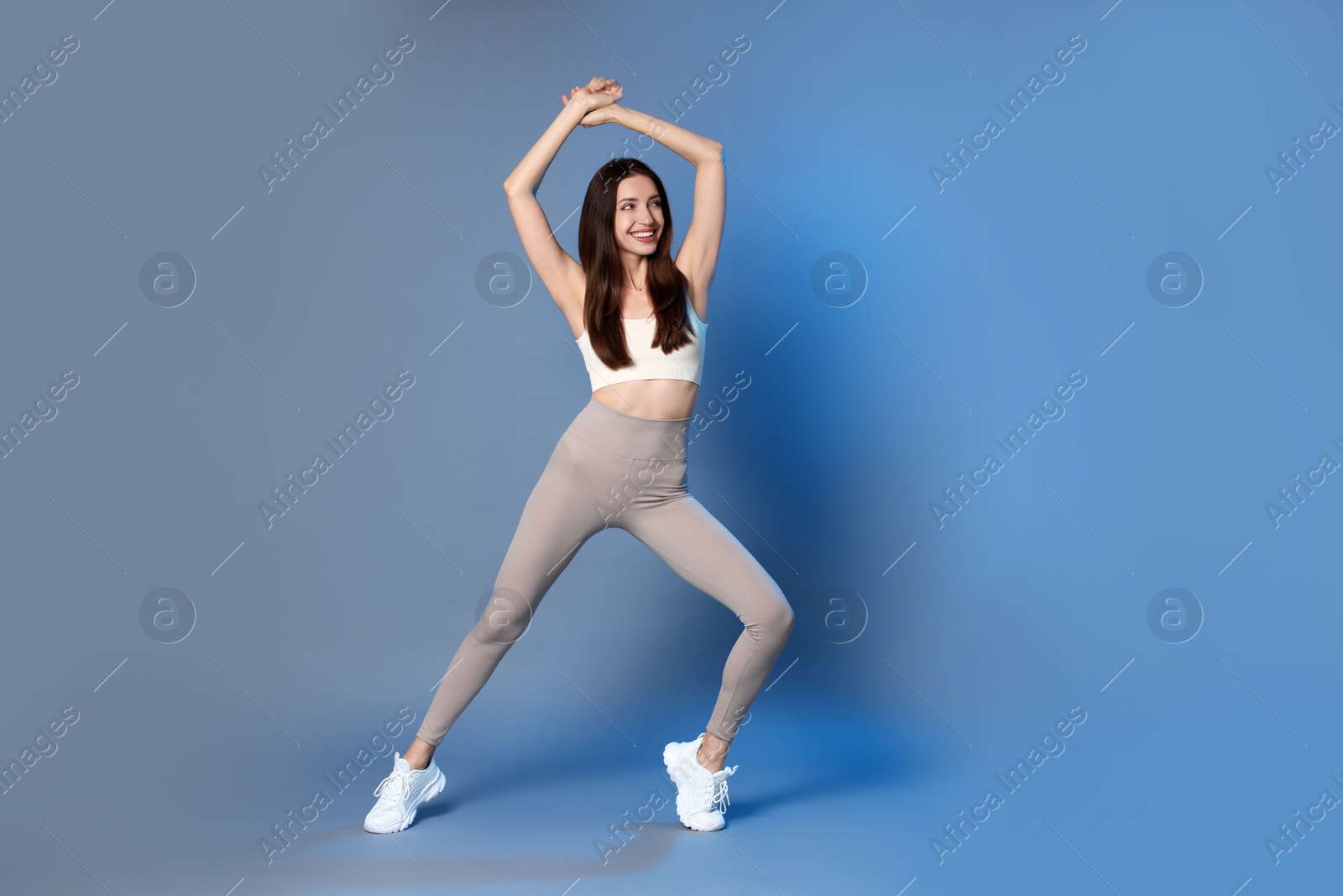 Photo of Beautiful woman in stylish sportswear on grey background