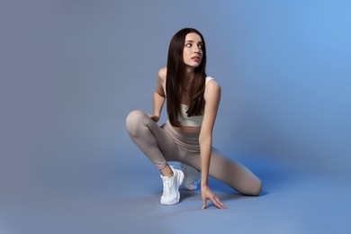 Beautiful woman in stylish sportswear on grey background