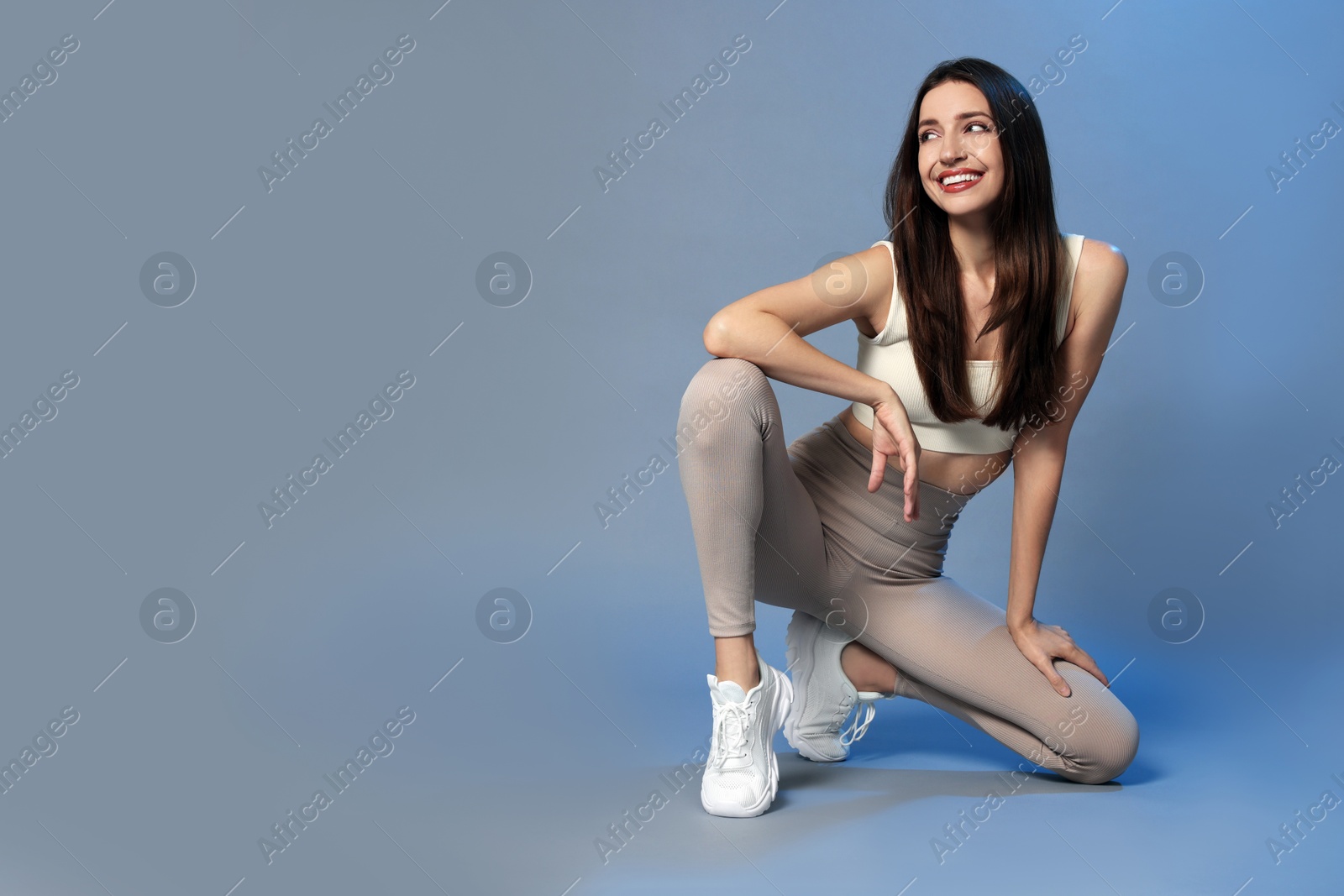 Photo of Beautiful woman in stylish sportswear on grey background. Space for text