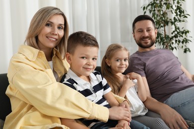 Photo of Happy parents and their children on sofa at home