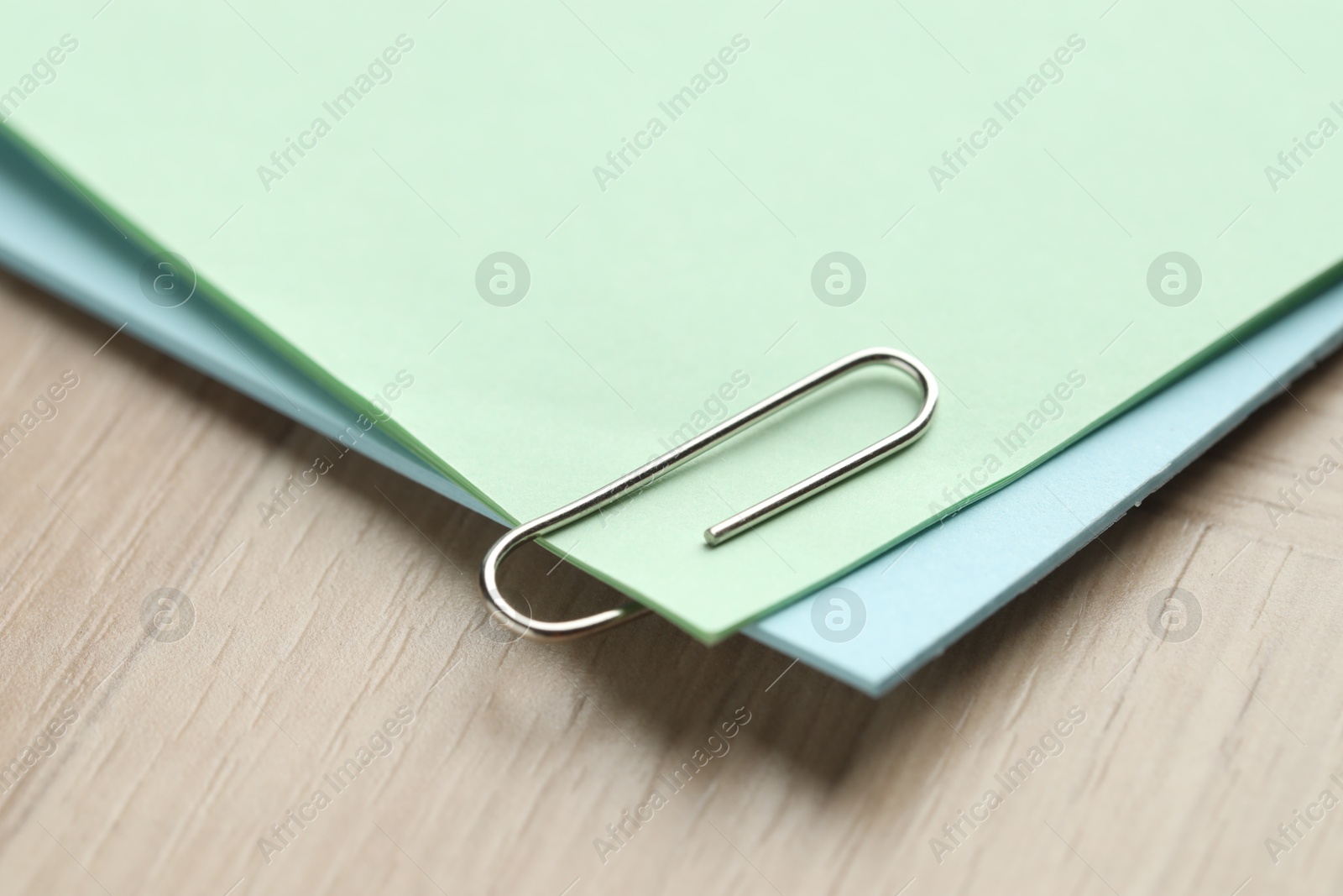 Photo of Paper notes with clips on wooden table, closeup